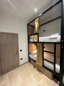 two bunk beds in a room with a door at Central Boutique Hostel in Sarandë