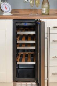 a kitchen with an oven with wine bottles in it at Four Oaks Cottage in Rockcliffe