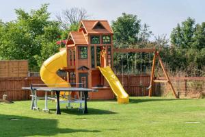 un parque infantil con tobogán y estructura de juegos en Four Oaks Cottage en Rockcliffe