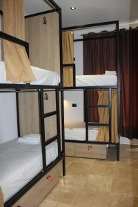 a room with three bunk beds in a room at Central Boutique Hostel in Sarandë