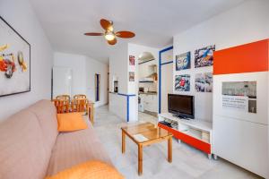 een woonkamer met een bank en een tv bij HomeForGuest Bright studio in La Carihuela near the beach in Torremolinos