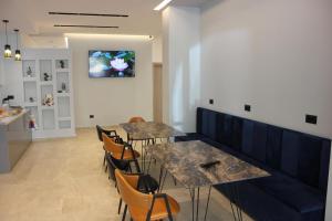 een restaurant met tafels en stoelen en een tv aan de muur bij Central Boutique Hostel in Sarandë