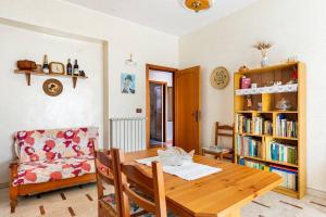 a living room with a wooden table and a book shelf at Alloggio incantevole: Licata in Licata