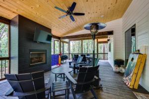 a screened porch with chairs and a table and a ceiling fan at Family-Friendly Broken Bow Home with Deck and Grill! in Broken Bow