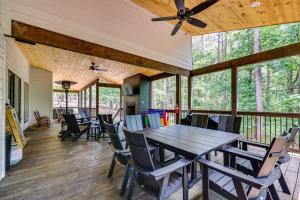 a large screened porch with a wooden table and chairs at Family-Friendly Broken Bow Home with Deck and Grill! in Broken Bow