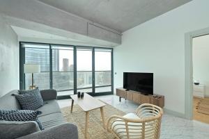 a living room with a couch and a tv at Gorgeous Modern 1bd Terracepoolviews! #183 in Istanbul