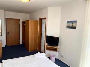 a hotel room with a bed and a tv at Hotel Nordwind in Lohme