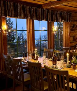 a dining room with a table and a large window at Buustamons Fjällgård in Åre