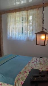a bedroom with a bed with a light on it at Canto Alto, Encanto in Petrópolis