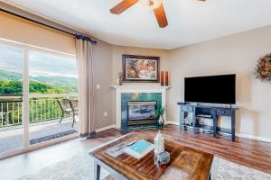 a living room with a fireplace and a flat screen tv at Pigeon Forge Perfection in Pigeon Forge
