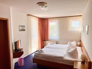 ein Hotelzimmer mit einem Bett und einem TV in der Unterkunft Hotel Nordwind in Lohme