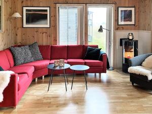 un soggiorno con divano rosso e tavolo di Apartment Vossestrand III a Vossestrand