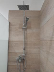 a shower in a bathroom with a wooden wall at Central House 2 in Ancient Epidauros
