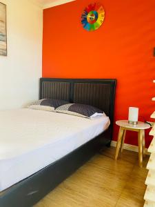 a bedroom with an orange wall with a bed and a table at Dollosa Compound in Iba