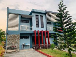 a blue house with red columns in front of it at Dollosa Compound in Iba