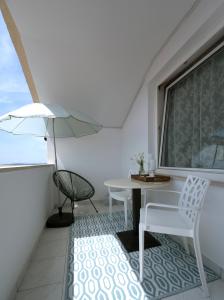 ズボヴィチにあるL'infini Sea View apartments Zubovićiのバルコニー(テーブル、椅子付)、窓が備わります。