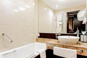 a bathroom with a sink and a shower and a tub at Crowne Plaza Bratislava, an IHG Hotel in Bratislava