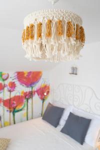un lampadario pendente bianco appeso sopra un letto in una stanza di L'infini Sea View apartments Zubovići a Zubovići