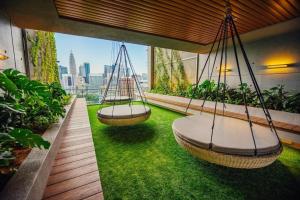twee schommels op een balkon met groen gras bij Ceylonz Leisure Suites KLCC in Kuala Lumpur