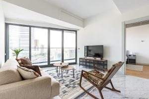 a living room with a couch and a tv at Gorgeous Modern 1bd Terrace Condopoolviews! #233 in Istanbul