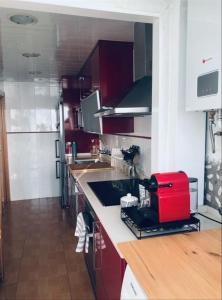 a kitchen with a red appliance on a counter at Piso Jùlia in Mataró