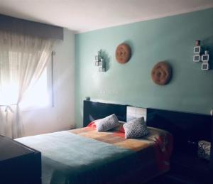 sypialnia z łóżkiem i 2 maskami na ścianie w obiekcie Piso Jùlia w mieście Mataró