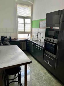 een keuken met zwarte kasten en een tafel. bij Wonderful flat near Ku’damm in Berlijn