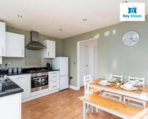 a kitchen with a wooden table and a kitchen with white appliances at Spacious Contractor House Leisure By Keysleeps Short Lets Derby With Free Parking in Derby