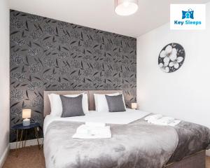 a bedroom with a large bed with a black and gray wall at Spacious Contractor House Leisure By Keysleeps Short Lets Derby With Free Parking in Derby
