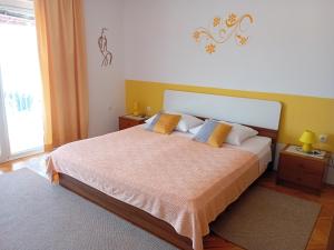 a bedroom with a large bed with yellow walls at Apartments Heidi in Portorož