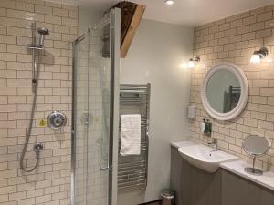 bagno con doccia, lavandino e specchio di The Stork Hotel a Lancaster Altre 37 foto