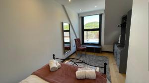a bedroom with a bed and a mirror and a chair at 3 chapel row cottages in Wirksworth