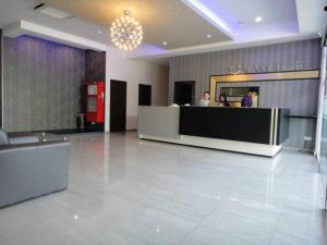 a lobby of a hotel with two people at a counter at Galaxy Hotel SIMPANG AMPAT in Simpang Ampat