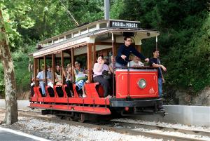a group of people riding on a red trolley at Casa Mateus - Colares, Parque Natural Sintra Cascais in Sintra