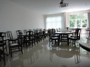 a room with tables and chairs and a room with windows at Galaxy Hotel in Simpang Ampat