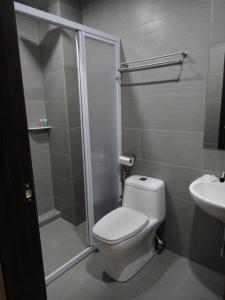 uma casa de banho com um chuveiro, um WC e um lavatório. em Galaxy Hotel em Simpang Ampat