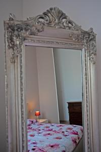 a large mirror in a bedroom with a bed at Casa Dafne in Livorno