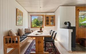 a dining room with a table and a couch at 2 Bedroom Nice Home In Jægerspris in Jægerspris