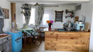 a kitchen with a table and a kitchen with blue appliances at Wheelhouse - Grinkle Bell Cottage in Saltburn-by-the-Sea