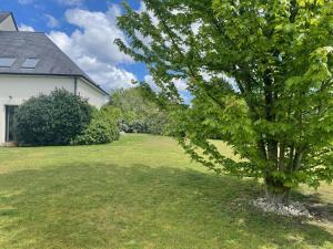 Ein Baum in einem Hof neben einem Haus in der Unterkunft Maison Proche de Le Mans Classique in Changé