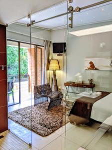 a bedroom with a bed and a glass wall at Alpine Attitude Boutique Hotel & Conference Venue in Pretoria