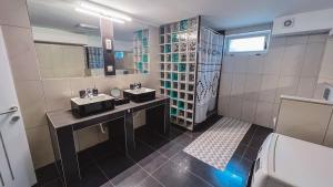 a bathroom with two sinks and a shower at Cozy Apartman in Leisbach 