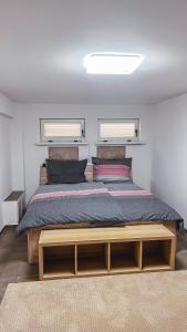 a bedroom with a large bed with two windows at Cozy Apartman in Leisbach 