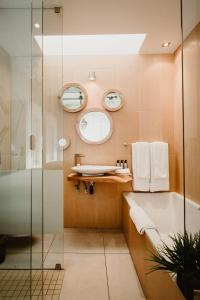 a bathroom with a sink and a tub and a mirror at Alpine Attitude Boutique Hotel & Conference Venue in Pretoria