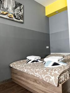 Bett in einem Zimmer mit Wandgemälde in der Unterkunft — Затишні Apartments — in Iwano-Frankiwsk