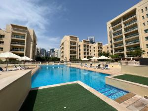 a large swimming pool in a city with buildings at Luton Vacation Homes - Cozy1BR , Al Dhafra Tower 1 - Dubai Greens - 40AB1 in Dubai