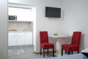 a kitchen with two red chairs and a table at Central Eden - ZF Hvar in Hvar +18 photos