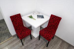 a white table with two red chairs and a book on it at Central Eden - ZF Hvar in Hvar