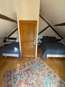 Zimmer im Dachgeschoss mit 2 Betten und einem Teppich in der Unterkunft Le Logis Du Regisseur Gite in Charny