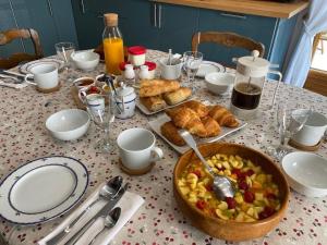 a table topped with a table with food and bread at Le Logis Du Regisseur Gite in Charny